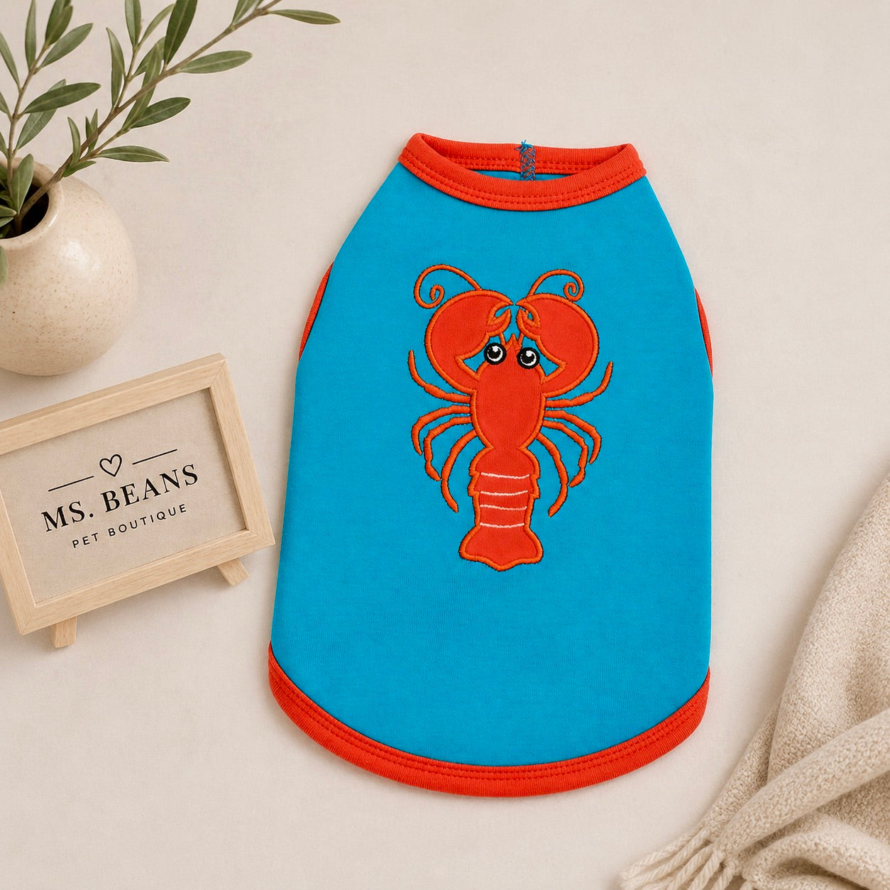 Blue Crab dog tank top featuring a red lobster graphic.